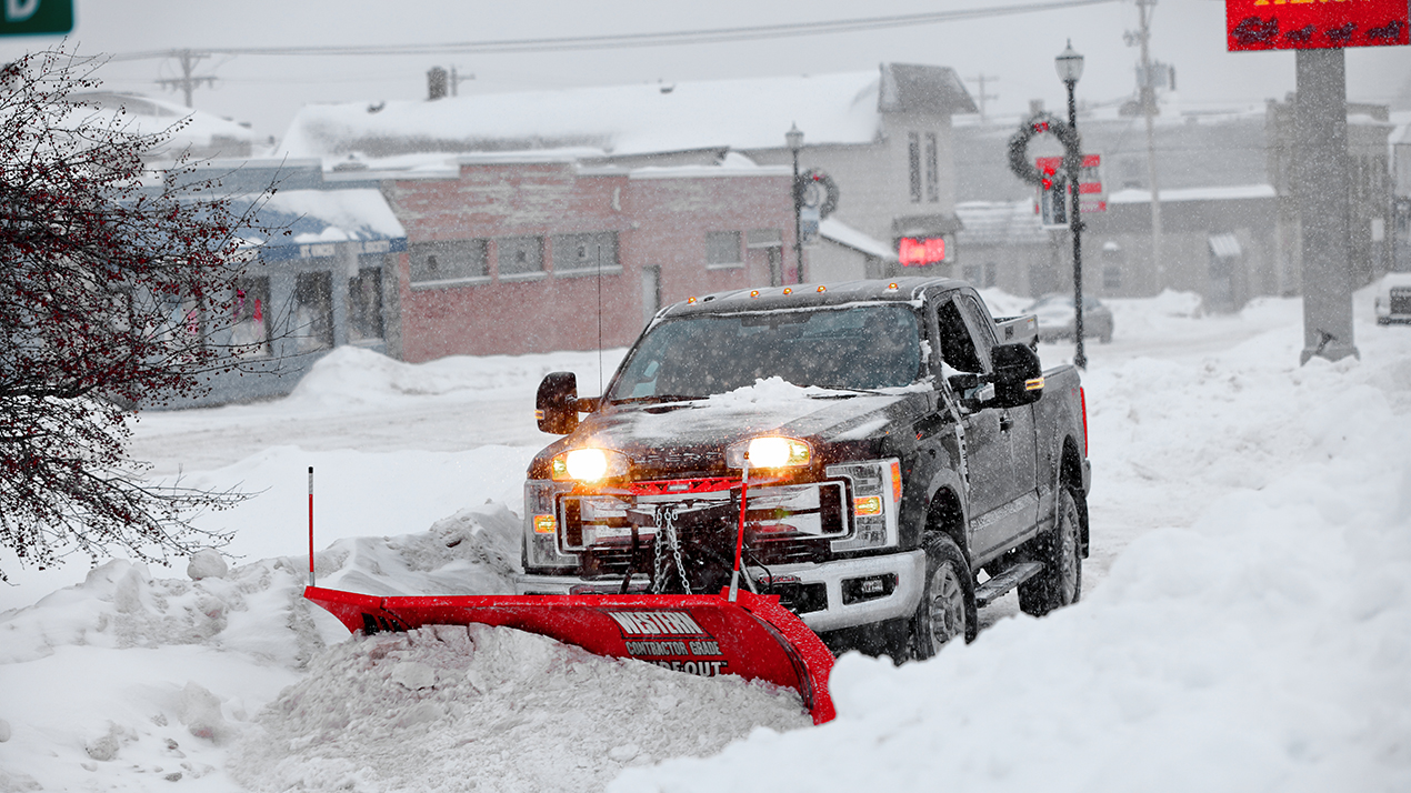 Western plow plowing street of snow